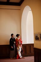 旧古河庭園洋館の廊下で並んで和装の婚礼前撮りを撮る紋付き袴の新郎と赤い色打掛の新婦
