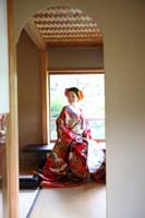 和室で和装の婚礼前撮りをする赤い色打掛を着た新婦の一人の写真