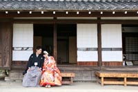 東京のお茶室がある日本庭園で、仲良くくつろぐ新郎と赤い色打掛を着た新婦の和装前撮り