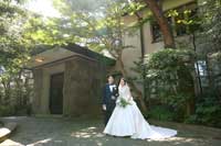 緑に囲まれた重厚な細川邸でにっこり佇む新郎新婦